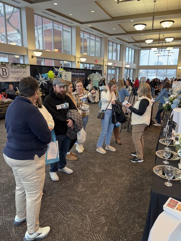 Couples and families walking the exhibitor aisle