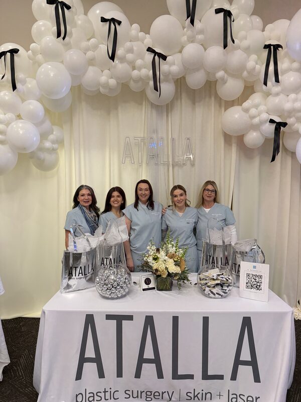 An exhibitor team smiling behind their booth table