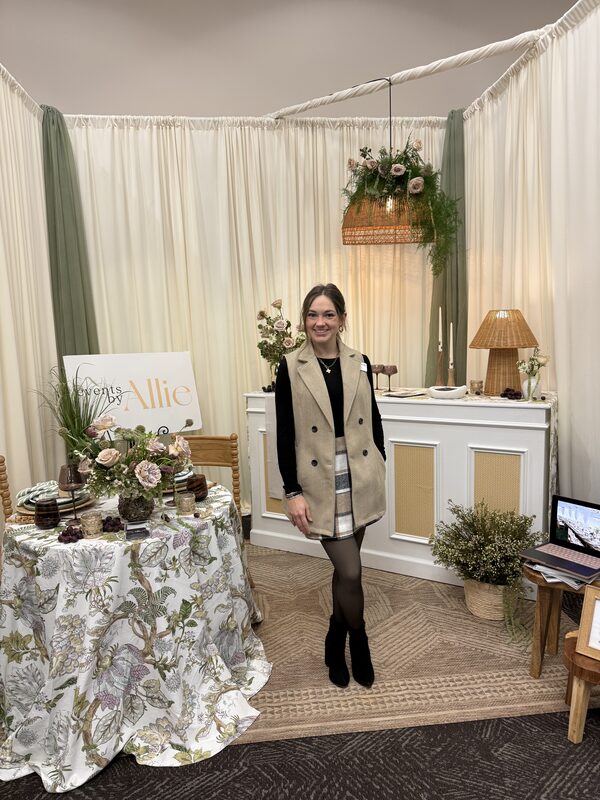 An exhibitor standing in a styled booth
