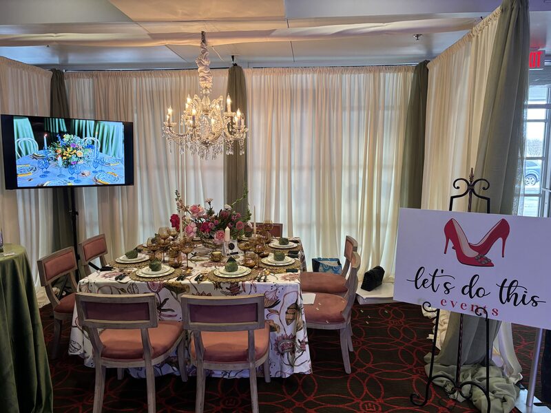 A styled reception table under a crystal chandelier